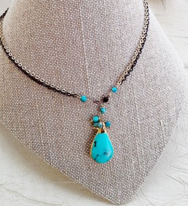 Turquoise pendant on gold and black chain